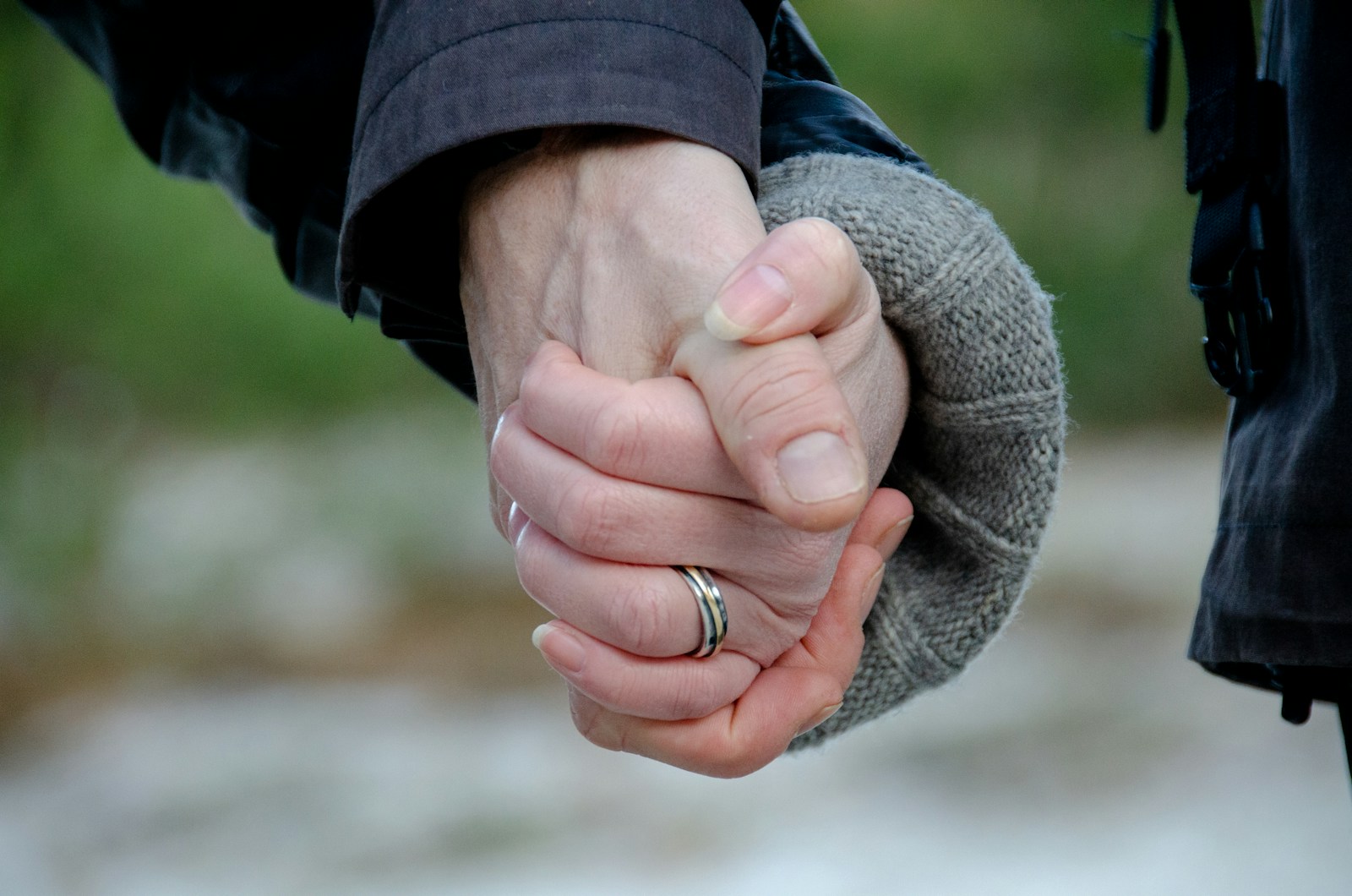 person in blue jacket holding womans hand symbolizing them rebuilding trust